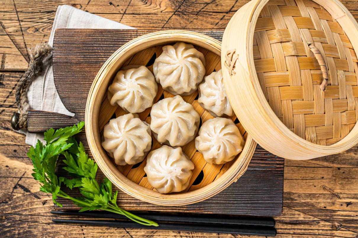 Momo Dumplings in a Bamboo Steamer. Wooden Background. Top View